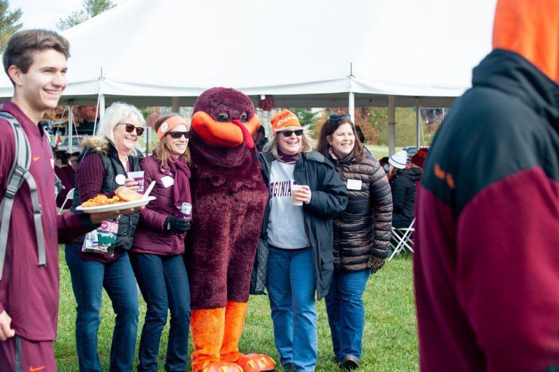 Hokie Bird poses with alumni at a late fall tailgate